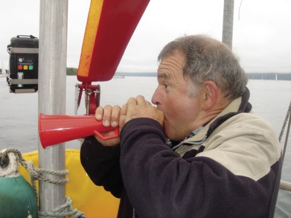 Avec conviction, le capitaine salue nos hôtes de Gaspé et sonne le départ de la remontée du Saint-Laurent. / cliché P.L. Bouchet