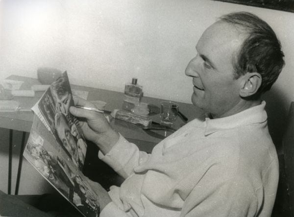 Bourvil, dans sa loge, au Casino Municipal s'apprête à signer un magazine pour un fan. / Photo : Henri Marcou