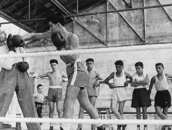 Dans les années 50, entraînement au Château de Mons : l'entraîneur Jo Justin (à gauche) donne une leçon à Pedro sous l'œil attentif des jeunes et de P. Chivilo (2e en partant de la gauche). / Coll. P. Chivilo