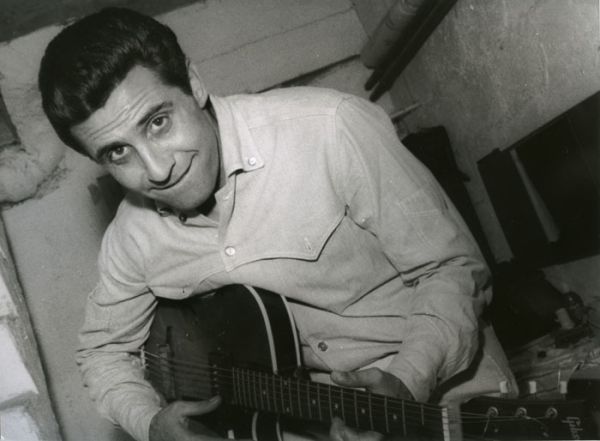 Gilbert Bécaud s'essaye à la guitare sur une superbe Gibson Jazz. / Photo : Henri Marcou