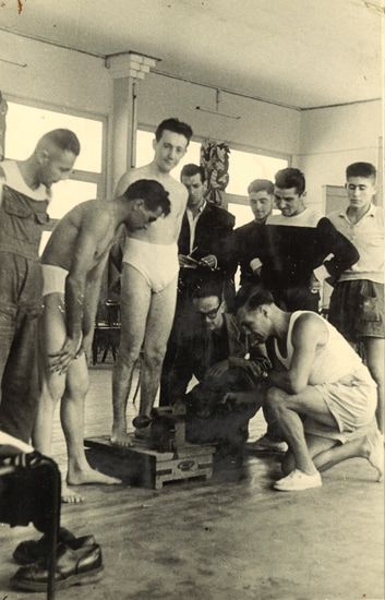 La pesée avant une rencontre au casino en bois. À gauche, Jo Justin, accroupi, Michelot, champion olympique à Berlin, sur la balance, Tinot de Poitiers, à l'extrème droite, P. Chivilo. / Coll. P. Chivilo