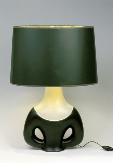 Pied de lampe buste en faïence. Circa 1955. Email noir lustré et blanc cassé finement piqueté de noir, liseré vert d'oxyde entre les deux teintes. H : 31 cm. Signature manuscrite incisée. Coll. P. Chambost / Visuel : D.R.