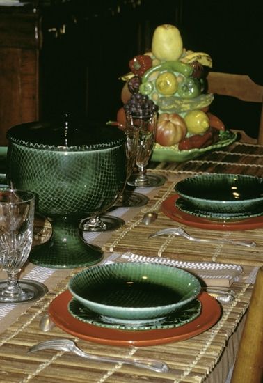 Service de table en faïence. Circa 1956. - Coupe haute sur pied douche formant calice. Email « au filet » vert brillant intérieur et extérieur. H : 23 cm. - Assiettes creuses, émail « au filet » vert, diamètre 21 cm. - Assiettes plates - éma / Visuel : D.R.