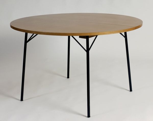 Table de salle à manger circulaire à plateau en orme sur un piétement en métal laqué noir. 1957, Edition Meubles TV - fiftease. H : 73, ø : 120 (cm) / Visuel : D.R.
